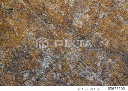 Texture of natural stone. A grey granite stone with cracks and rusty stains. 65972603