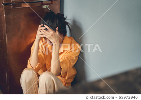 Upset young woman sitting on the floor at home 65972940