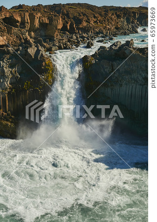 The Power of Nature. Amazing view of the old volcanic cliff with small waterfall in Iceland, Europe. Powerful mountain river. Icelandic nature landscape The Power of Nature. Amazing view of the old volcanic cliff with small waterfall in Iceland, Europe. Powerful mountain river. Icelandic nature landscape 65973669