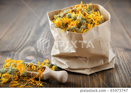 Paper bag of healing calendula herbs. Paper bag of healing calendula herbs. 65973747