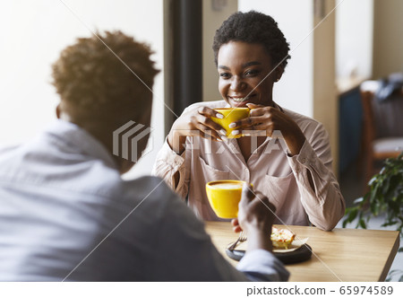 Happy African American couple on first date in cafe, talking and enjoying each other Happy African American couple on first date in cafe, talking and enjoying each other 65974589