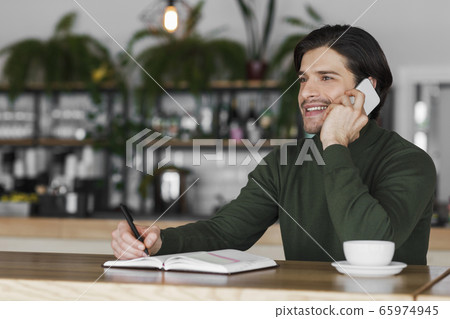 Excited businessman talking to business clients on phone 65974945