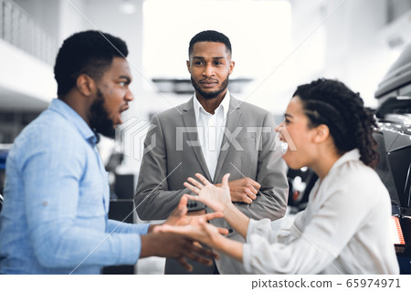 Dealer Looking At Spouses Having Quarrel About Buying Vehicle Indoor Dealer Looking At Spouses Having Quarrel About Buying Vehicle Indoor 65974971