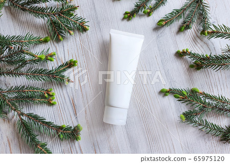 Top view of mock up / 3d model of white squeeze bottle plastic tube. Wooden background and branches of a Christmas tree. Concept bio organic beauty products. Christmas gift concept. Top view of mock up / 3d model of white squeeze bottle plastic tube. Wooden background and branches of a Christmas tree. Concept bio organic beauty products. Christmas gift concept. 65975120