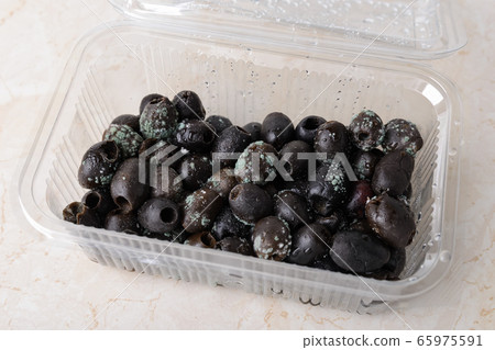 Spoiled olives with white green mold in a plastic food container on a kitchen table Spoiled olives with white green mold in a plastic food container on a kitchen table 65975591