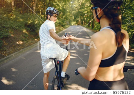 Sports couple riding bikes in summer forest 65976122