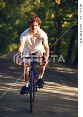 Sports man riding bike in summer forest 65976146