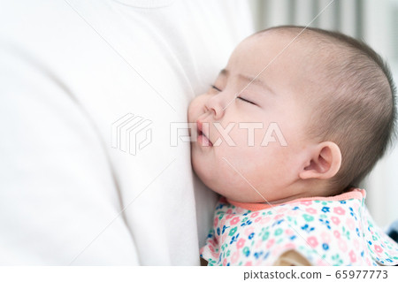 Baby sleeping on father's chest 65977773
