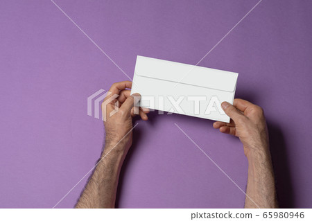Male hand holding a letterhead paper envelope Male hand holding a letterhead paper envelope 65980946