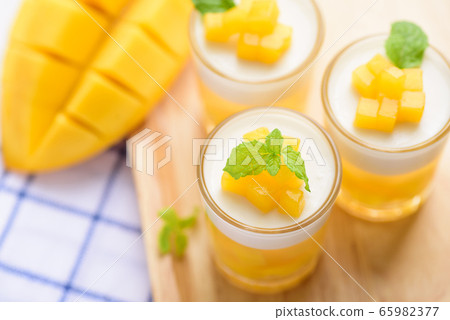 Thai dessert mango pudding, ripe mango dip in agar and coconut milk jelly on top  in the glass  65982377