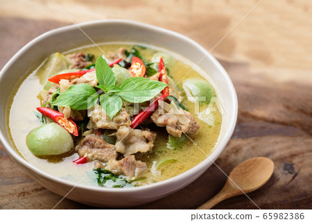 Thai food, Green curry with pork (Kang Keaw Wan) in a bowl and spoon on wooden background 65982386