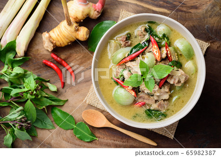Thai food, Green curry with pork (Kang Keaw Wan) in a bowl with ingredients on wooden background Thai food, Green curry with pork (Kang Keaw Wan) in a bowl with ingredients on wooden background 65982387