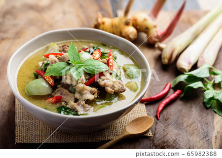 Thai food, Green curry with pork (Kang Keaw Wan) in a bowl with ingredients on wooden background Thai food, Green curry with pork (Kang Keaw Wan) in a bowl with ingredients on wooden background 65982388
