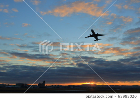 Airplane taking off from Osaka Itami Airport with the first sunrise in the background 65985020