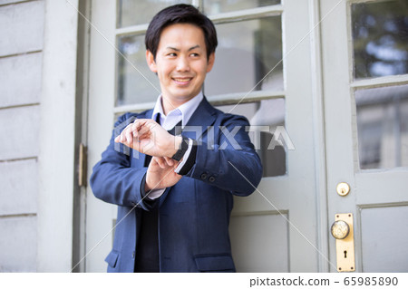 Asian businessman looking at wrist watch Asian businessman looking at wrist watch 65985890