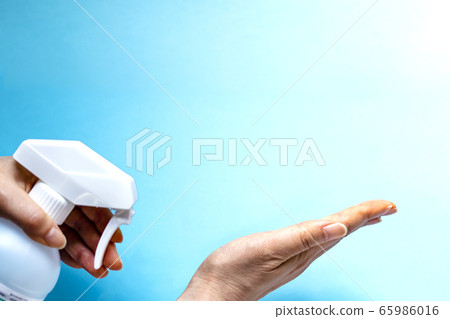 婦女的手,消毒用的瓶子,複製空間和淺藍色背景婦女的消毒手的地方 婦女的手,消毒用的瓶子,複製空間和淺藍色背景婦女的消毒手的地方 65986016