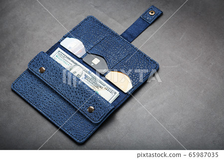 Blue purse with banknotes and credit cards on a Blue purse with banknotes and credit cards on a 65987035