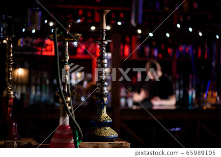 Barman fills black burnt ceramic bowl for hookah 65989105