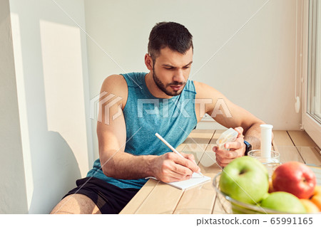 Handsome gentleman holding pills and making notes Handsome gentleman holding pills and making notes 65991165