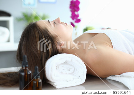 Girl in towel lies at reception massage therapist Girl in towel lies at reception massage therapist 65991644