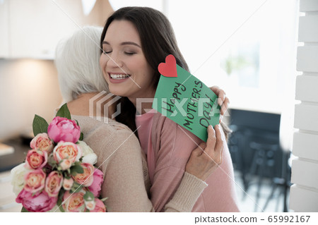 Loving daughter embracing her mother on a festive day 65992167