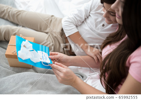 Contented Caucasian woman rejoicing over her gift Contented Caucasian woman rejoicing over her gift 65992555