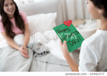 Male child congratulating his mother on a holiday 65992577