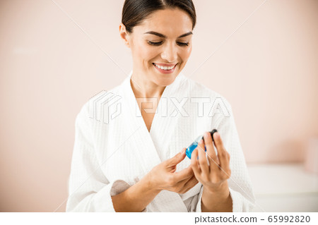Happy woman using serum for face care Happy woman using serum for face care 65992820