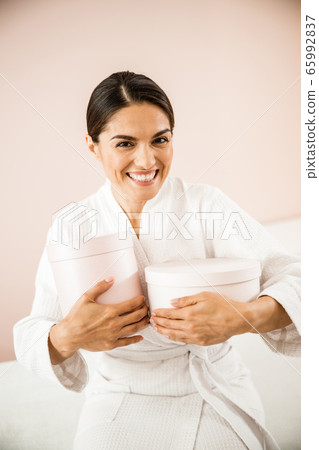 Cheerful woman rejoicing at presents for beauty care Cheerful woman rejoicing at presents for beauty care 65992837