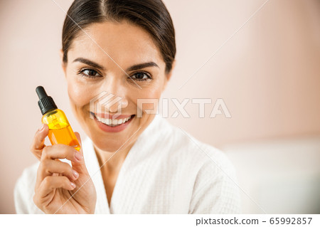 Happy pretty female holding bottle with cosmetic Happy pretty female holding bottle with cosmetic 65992857
