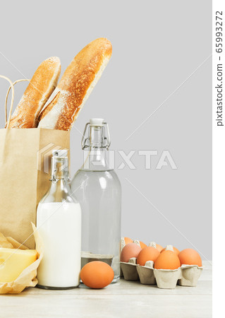 Two french baguette bread loafs in paper bag and Two french baguette bread loafs in paper bag and 65993272