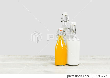 Three glass bottles with milk water and juice Three glass bottles with milk water and juice 65993274
