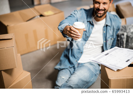 Happy attractive man with hot drink in new flat Happy attractive man with hot drink in new flat 65993413