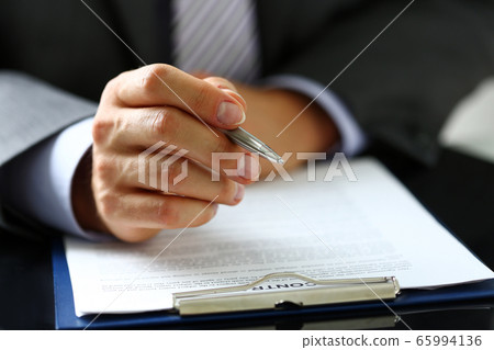Male arm in suit and tie fill form clipped to pad Male arm in suit and tie fill form clipped to pad 65994136