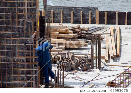 Workers are working on cement formwork frames. Workers are working on cement formwork frames. 65995076