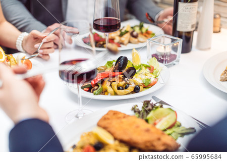 Close-up on Italian food on the table in restaurant with people eating 65995684
