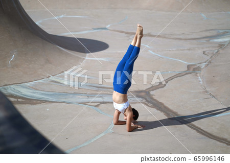 Asian chinese woman doing street yoga in public Asian chinese woman doing street yoga in public 65996146