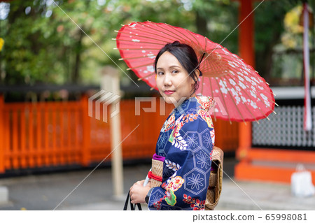 Geishas girl wearing Japanese kimono among red 65998081