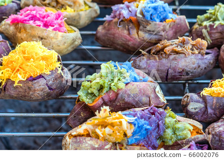 Colorful of many Thai traditional desserts stuffed in grilled yams on stove for sale on street food. Colorful of many Thai traditional desserts stuffed in grilled yams on stove for sale on street food. 66002076