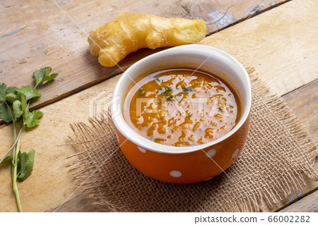 Cream soup of red lentils in a brown bowl, ginger and parsley Cream soup of red lentils in a brown bowl, ginger and parsley 66002282