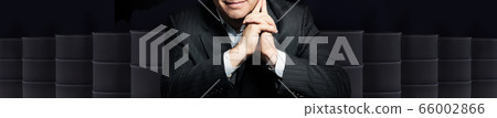 Happy smiling businessman with crude oil barrels 66002866