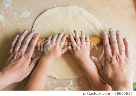 Children and dad hands rolled dough Children and dad hands rolled dough 66003635
