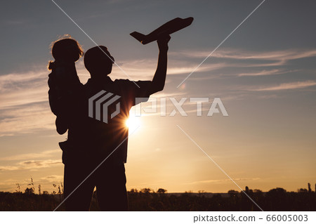 Father and son playing in the park at the sunset 66005003