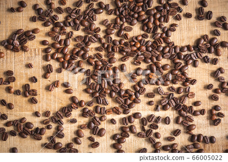 Roasted brown coffee beans spilled on wooden table Roasted brown coffee beans spilled on wooden table 66005022