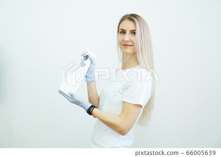 Woman holds spray bottle - antiseptic or detergent like guns. Health concept 66005639