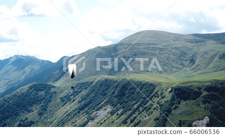 Paraglider flying over mountains during summer day - Georgia Paraglider flying over mountains during summer day - Georgia 66006536