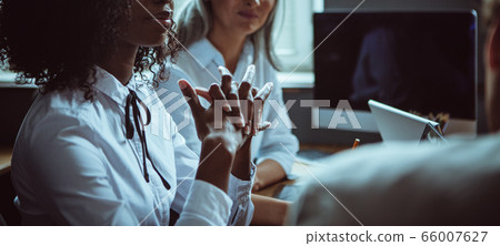 Young African woman expressively crossed her fingers worrying during team work. Abstract cropped defocused picture for background. Close up shot Young African woman expressively crossed her fingers worrying during team work. Abstract cropped defocused picture for background. Close up shot 66007627