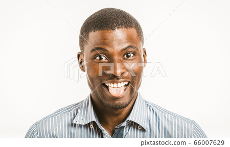 Funny African American man toothy smiles showing tongue while looking at camera. Young male entrepreneur in shirt isolated on white background. Head shoulders portrait. Emotions concept. Toned image 66007629