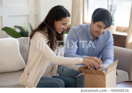 Happy young couple unbox cardboard box with online order 66008016