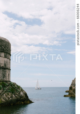 Sailing yacht at sea, sailing in the background Fort Bokar - on the walls of the old city of Dubrovnik, Croatia. Sailing yacht at sea, sailing in the background Fort Bokar - on the walls of the old city of Dubrovnik, Croatia. 66008244
